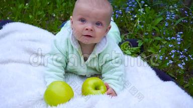 婴儿坐在草地上吃大苹果